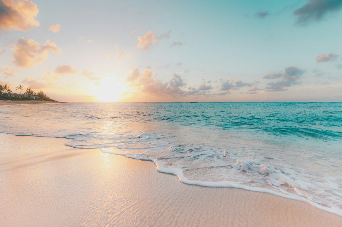 Sandy beach and gentle waves at sunset